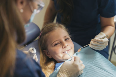 Dentists examining patient mouth in medical clinic