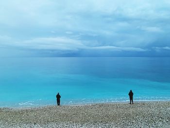 Rear view of man looking at sea against sky