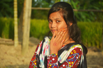 Portrait of young woman standing outdoors