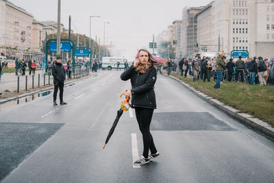 Woman on road in city against sky