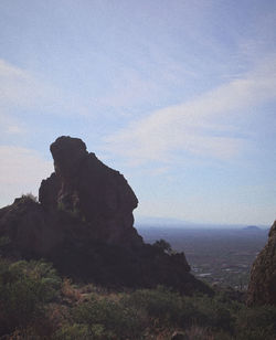 Scenic view of rocky mountain by sea against sky