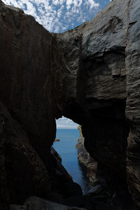 Rock formations by sea against sky