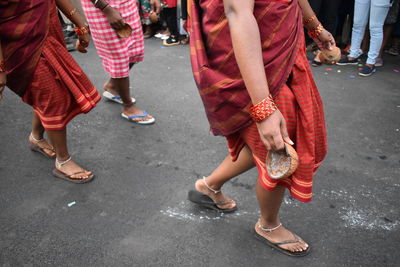 Low section of people dancing on road in city