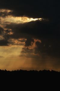 Low angle view of silhouette landscape against dramatic sky