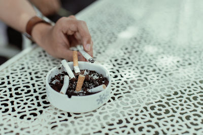 Midsection of person holding cigarette