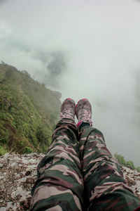 Low section of man in mountains against sky