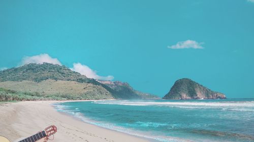 Scenic view of sea and mountains against sky