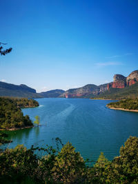 Scenic view of bay against clear blue sky