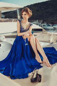 Beautiful young perfect girl in a dress and makeup, summer trip on a yacht with white sails on