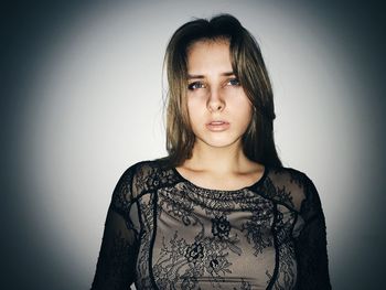 Portrait of beautiful young woman against gray background