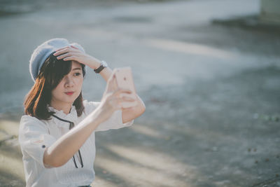 Young woman taking selfie with mobile phone