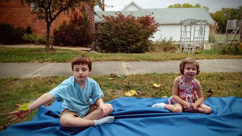 Smiling boy and girl playing while sitting in park