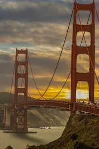 View of suspension bridge against cloudy sky