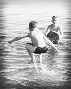 Full length of happy young man swimming in water