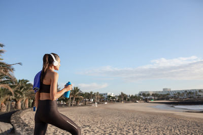 Beautiful fitness woman looking at the beach after training .