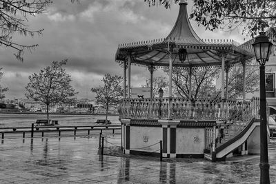 Built structure by river in park against sky