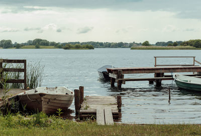 Boats moored in lake against sky