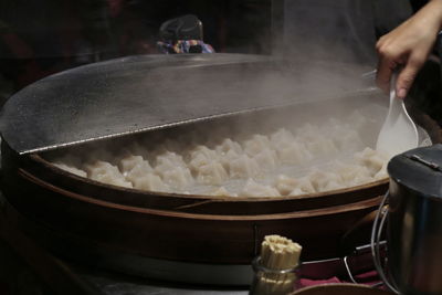 Cropped hand of woman preparing dumplings