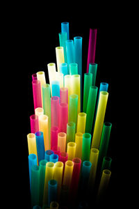 Close-up of colored pencils over black background