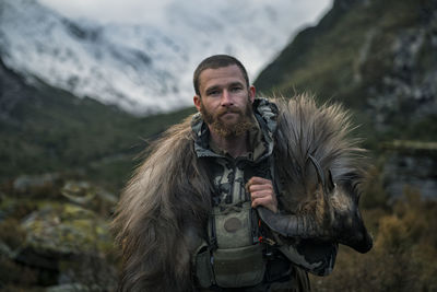 Hunter in mountains looking at camera