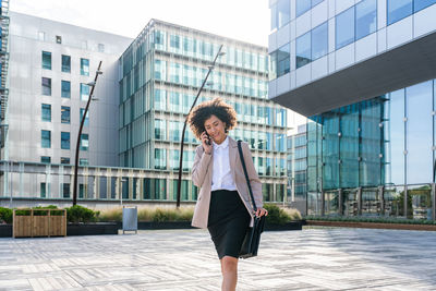 Portrait of young woman standing in city