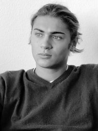 Portrait of a young man against wall at home