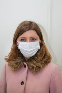 Young woman with protective face mask against white back ground