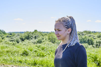 Portrait of teenage girl looking away on field