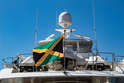 Low angle view of flag against clear blue sky