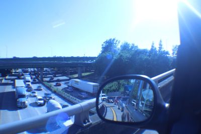 Reflection of trees in side-view mirror of car