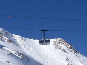 Low angle view of ski lift against blue sky