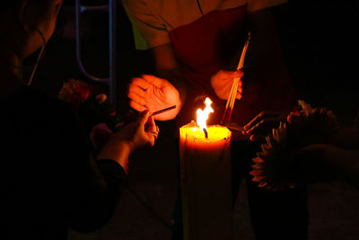 People holding burning candles