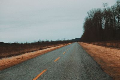 Empty road along countryside landscape