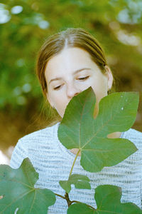 Close-up portrait of woman with green leaves