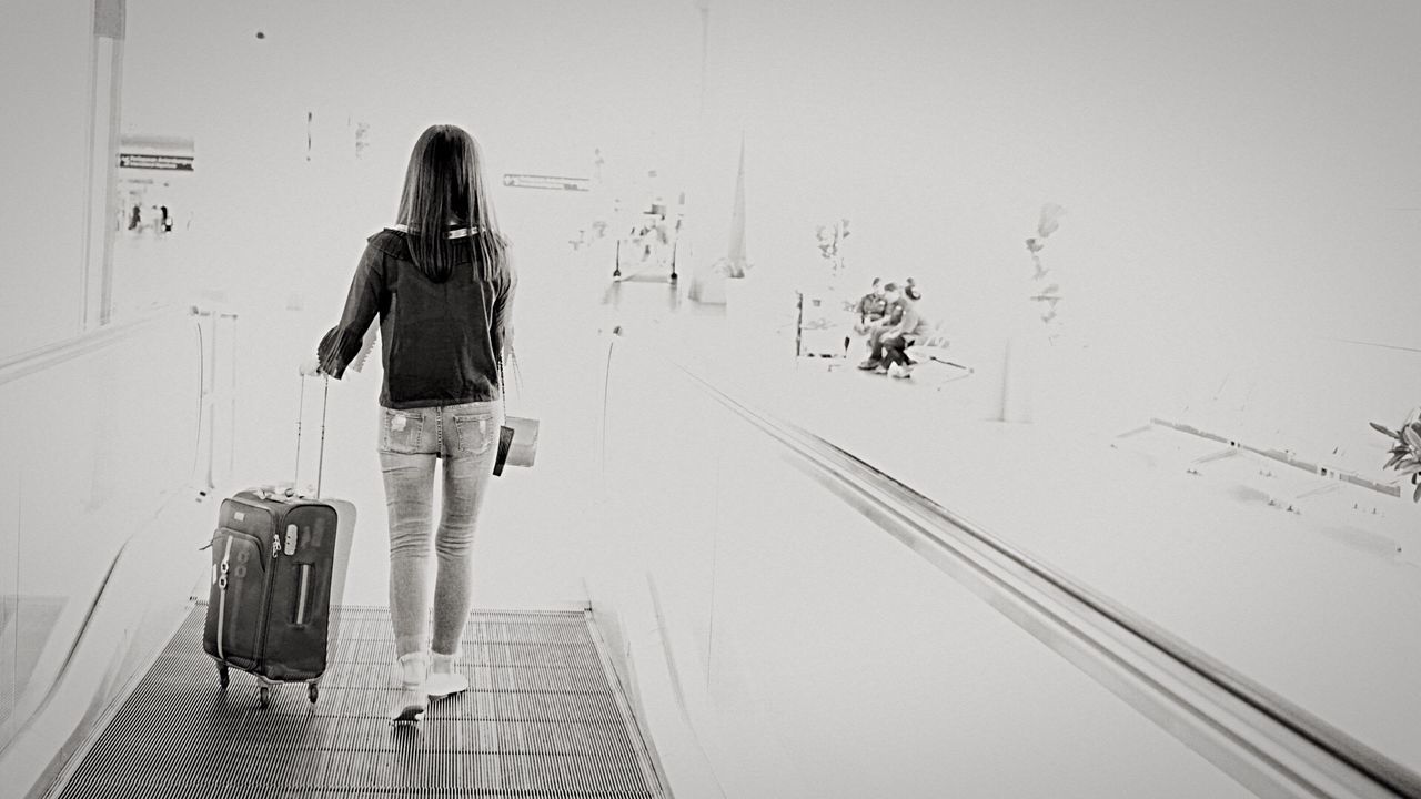 YOUNG WOMAN STANDING BY RAILING