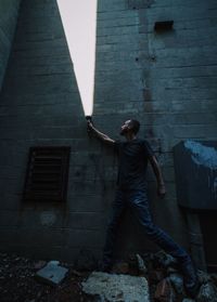 Full length of man standing on footpath against building