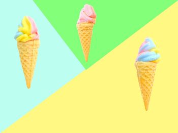 Close-up of ice cream cone against yellow umbrella