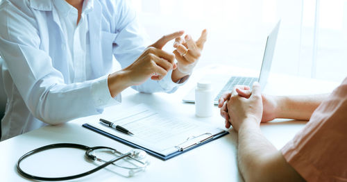 Midsection of doctor examining patient at clinic