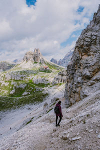 Rear view of man standing on mountain against sky