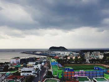 High angle view of buildings by sea against sky