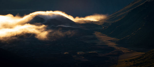 Panoramic view of volcanic mountain against sky during sunset