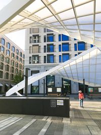 Rear view of man walking on modern building