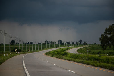 Road amidst field against sky