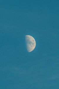 Low angle view of moon against blue sky at night