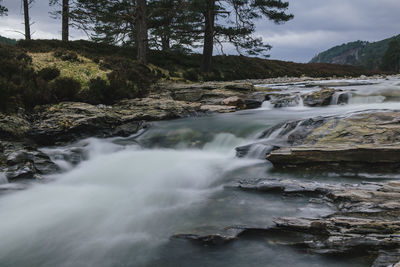 Scenic view of waterfall against sky