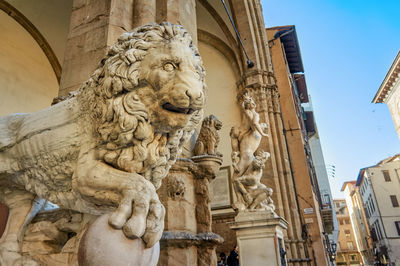 Low angle view of statue against building in city