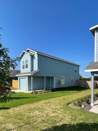 House on field against clear blue sky