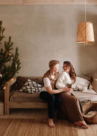 A man and a woman in love embrace give gift gifts celebrate a holiday at the christmas tree at home