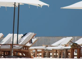 Lounge chairs and parasols arranged at beach