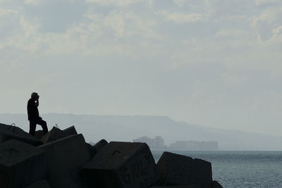 Man standing by sea against sky